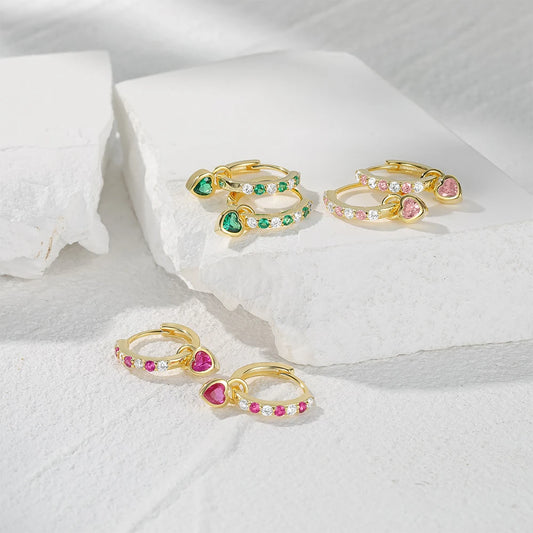 Heart hoop earrings featuring green and pink CZ hearts, set on a white stone background for showcasing elegant jewelry.