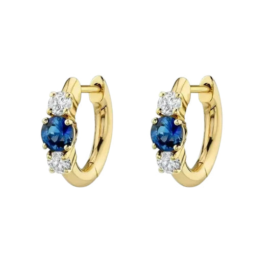 Gold huggie hoop earrings featuring blue and white cubic zirconia, crafted from 14k gold over sterling silver.