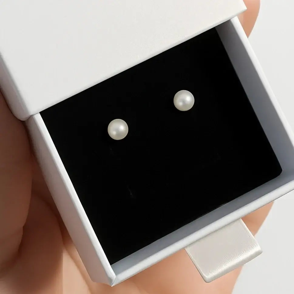 Pearl earrings in a white gift box, showcasing 4mm simulated pearl studs and elegant design.