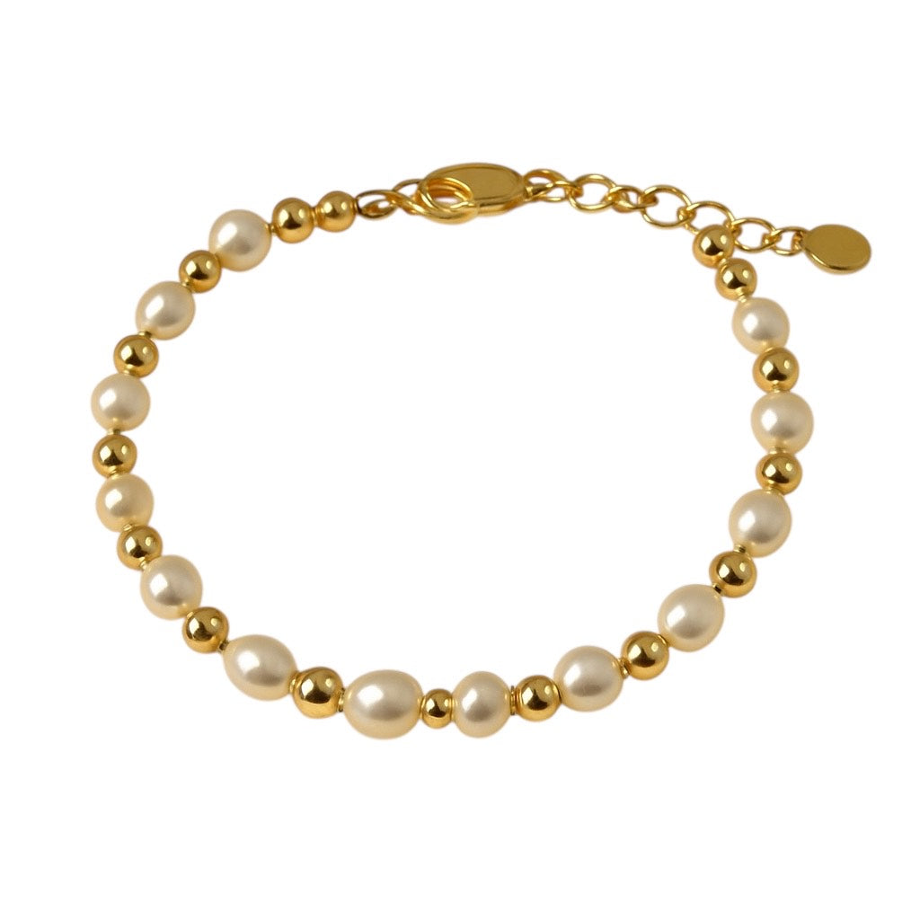 Children’s bracelet with alternating freshwater pearls and shiny gold beads, featuring a gold lobster clasp and heart charm, displayed on a white background