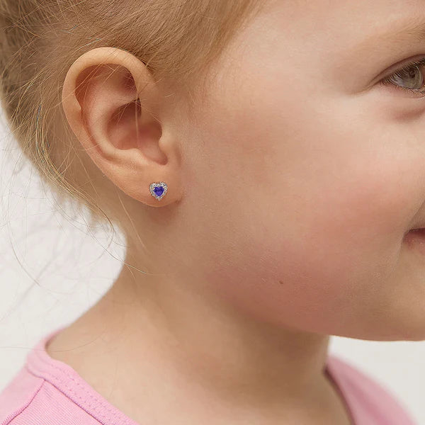 Close-up of a child wearing a purple heart stud earring.