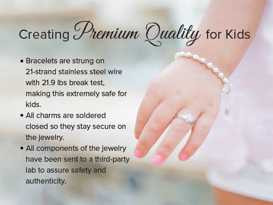 Hand wearing a sterling silver children's bracelet with pearls, showcasing premium quality and safety features for kids.