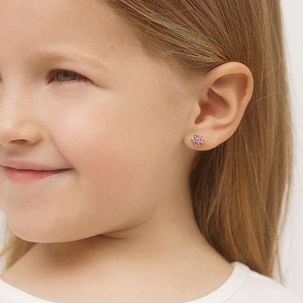 Girl wearing sterling silver flower stud earrings with safety screw backs