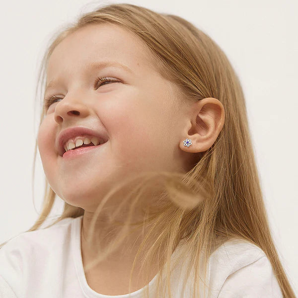 Girl wearing sterling silver flower stud earrings with safety screw backs
