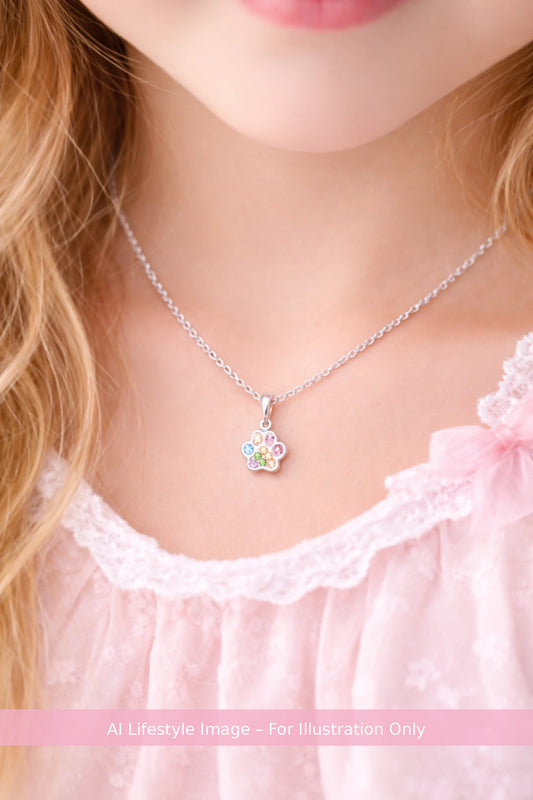 Close-up of a necklace with a colorful pendant worn by a person in a pink outfit.