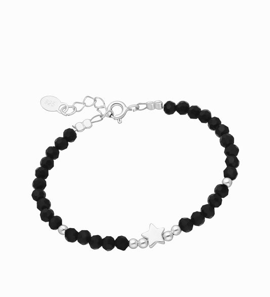 A sterling silver and black crystal bracelet with a star and small silver beads, designed for babies and children, presented on a gift box.