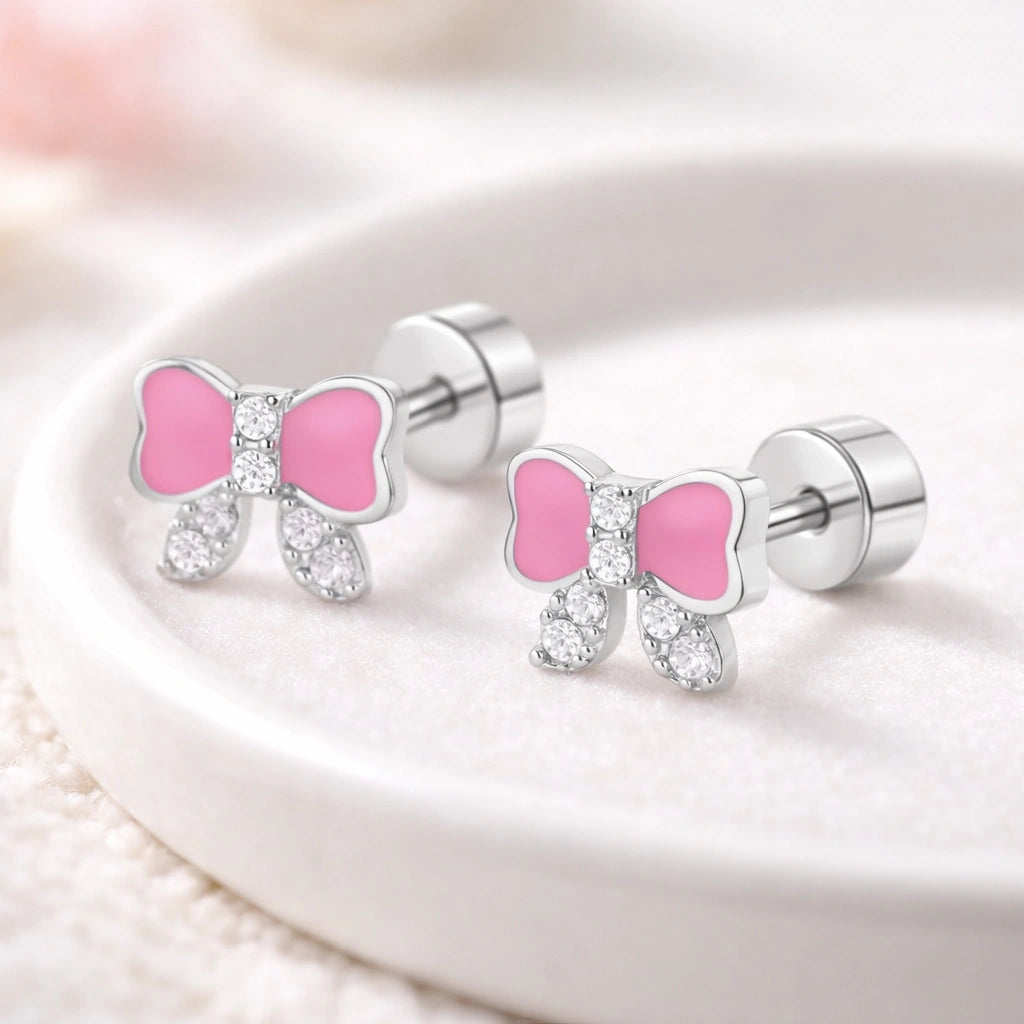 Children's Earrings featuring pink bow design with CZ accents in surgical steel screw-back studs.