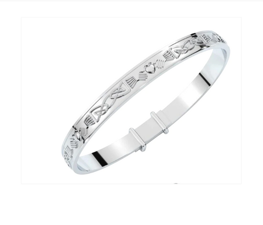 Sterling silver expandable baby bangle engraved all around with Claddagh heart, hands, and crown motifs in a continuous Celtic knot pattern, shown on a white background