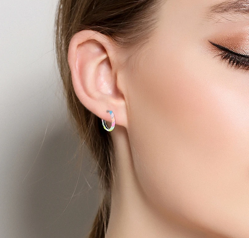 Close-up of a person wearing a colorful hoop earring with a neutral background