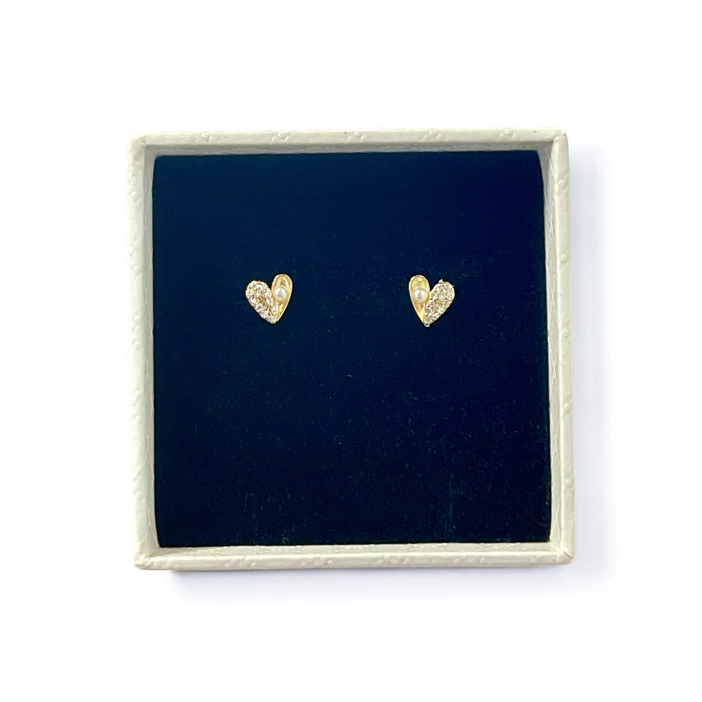Gold heart-shaped earrings in a white gift box with black velvet lining