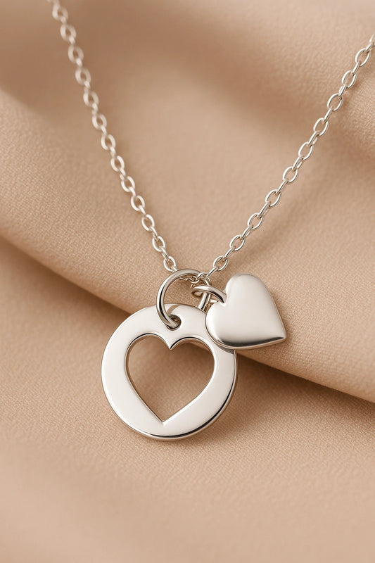 Heart necklace featuring a sterling silver disc with cut-out heart and attached heart charm, perfect gift for mothers.