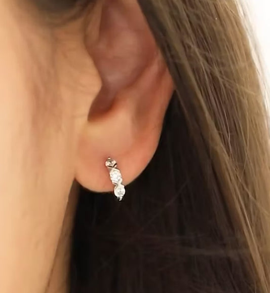sterling silver hoops with white cz close up in the ear of a young girl