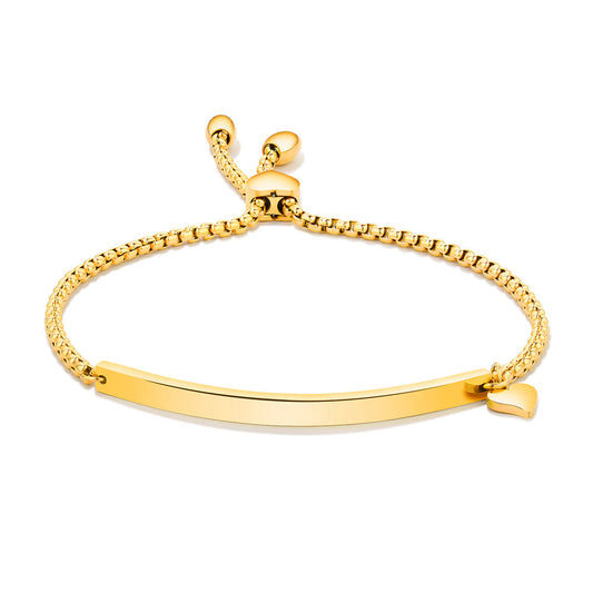 Polished gold plated adjustable bolo bracelet with a slim engravable ID bar on a box chain, sliding bead clasp, and tiny heart charm, shown on a white background.