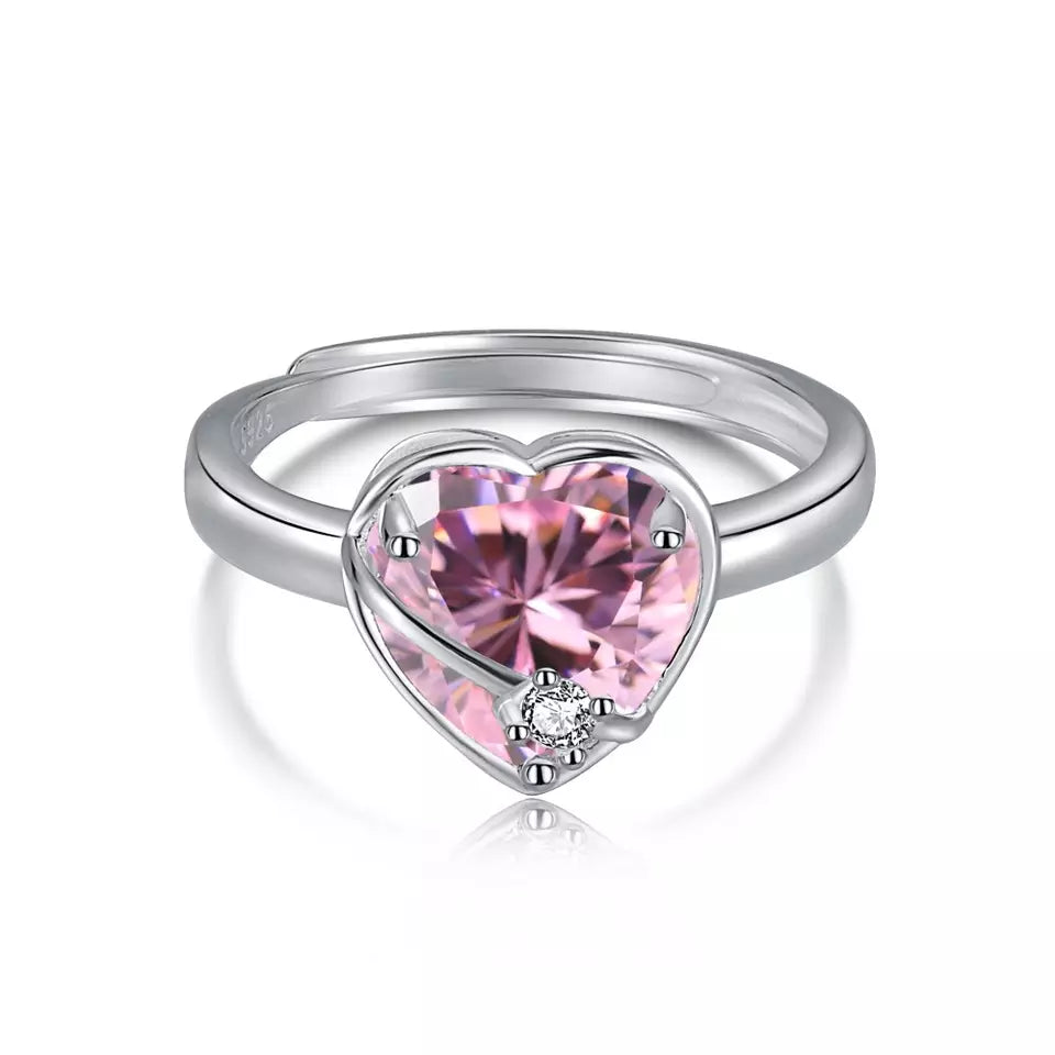 Adjustable sterling silver ring with a pink cubic zirconia heart wrapped in a silver ribbon, with a clear cubic zirconia at the center.