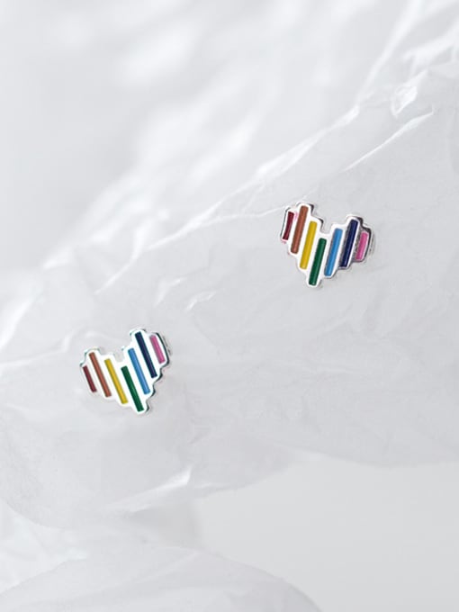 Pair of sterling silver heart studs with multi-coloured vertical stripes, artfully arranged on crumpled white tissue paper