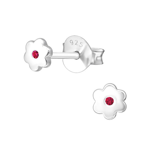 A pair of sterling silver flower earrings with a central ruby CZ, intended for baby girls representing the July birthstone.