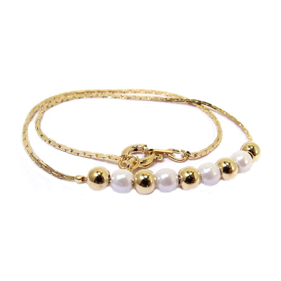 A gold-plated anklet featuring alternating man-made pearls and gold-plated balls, designed for children.