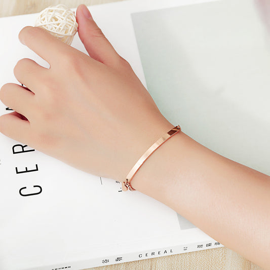Close up of a ladies wrist wearing a rose gold plated bolo bracelet with heart charm and engravable name plate