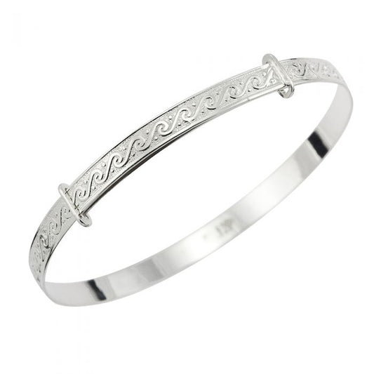 Sterling silver children’s expandable bangle with a continuous wave-pattern engraving along the top and two slider rings for adjustment, shown on a white background.