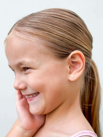 Pearl earrings worn by a young girl showcasing 14k gold over sterling silver pearl screw back studs.