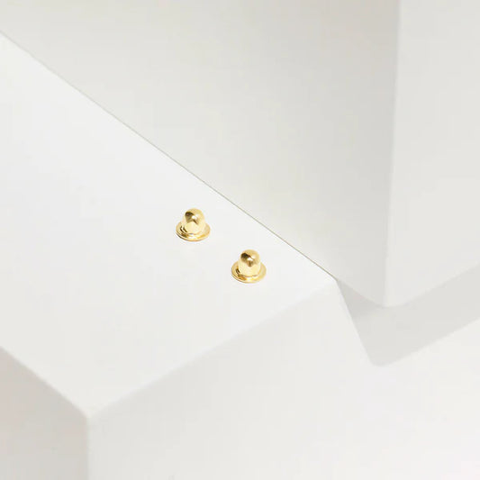 Two 14k solid gold screw back spares on a white background