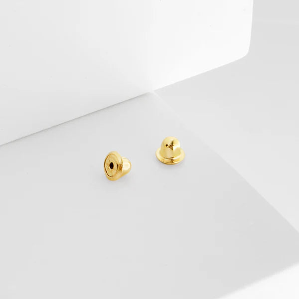 Pair of 14k solid gold screw back spares on a white background