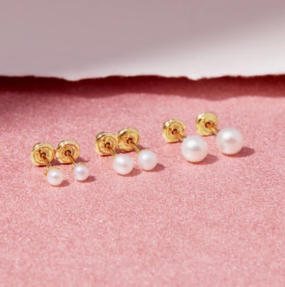 Set of pearl earrings with gold posts on a pink background