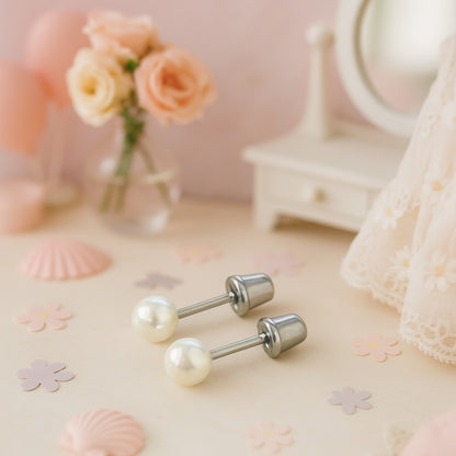 Pair of pearl earrings on a decorative surface with flowers and shells in the background