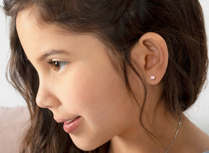 Profile view of a young girl wearing pink CZ earrings, showcasing the 4mm cubic zirconia stones, perfect for children.