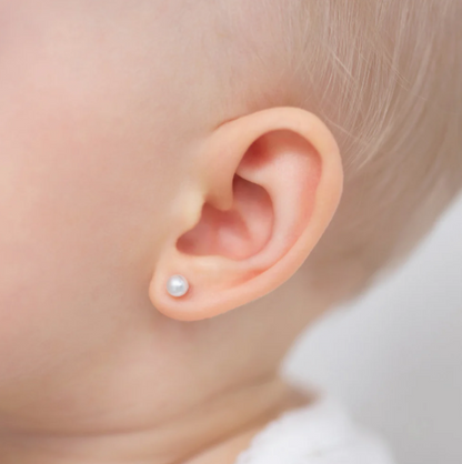 Close-up of a baby's ear with a pearl earring, showcasing baby pearl earrings with 3mm white simulated pearls.
