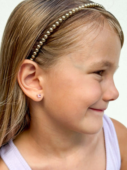 Children's earrings - 925 sterling silver pink Austrian crystal butterfly studs worn by a smiling girl.