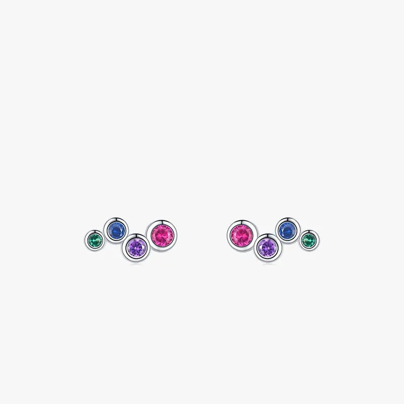 A pair of sterling silver earrings with bezel set colored CZs in blue, pink, green, and purple, designed for babies and children with push back closures.