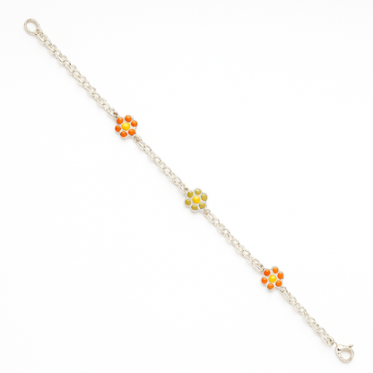 Diagonal product shot of a sterling-silver chain bracelet on a pure white background, featuring three enamel daisy charms—two with bright orange petals and one with pale green petals—spaced evenly along the chain, finished with an oval-link extension and lobster-clasp closure