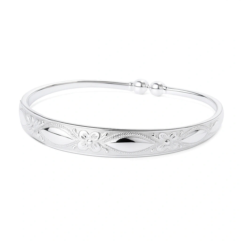 Children's bangle - silver plated embossed cuff featuring floral design and elegant finish.