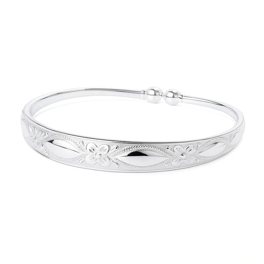 Children's bangle - silver plated embossed cuff featuring floral design and elegant finish.