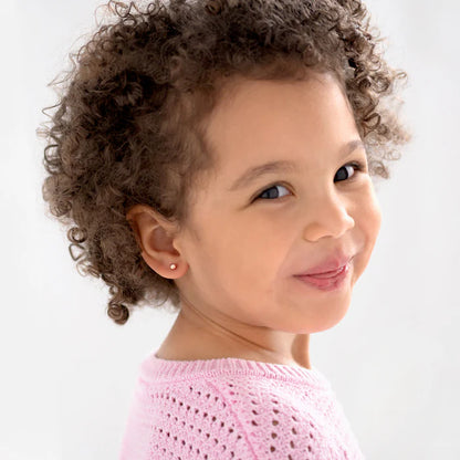 Smiling girl wearing children's earrings, showcasing 14k solid rose gold ball stud screw backs.