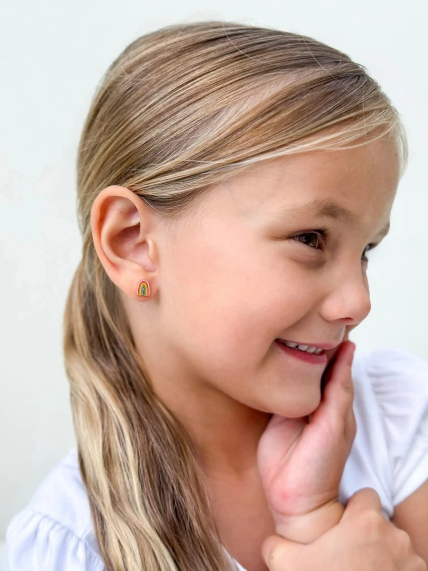 Child's ear showing 18k gold plated rainbow enamel stud earrings, highlighting the charm of children's earrings in a close-up view.