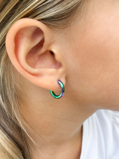 Children's earrings - 10mm anodised rainbow hoop earrings in a young child's ear.