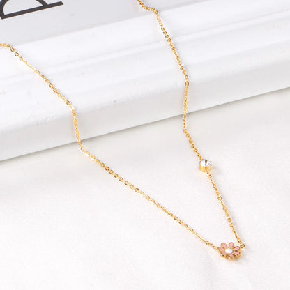 Daisy necklace featuring a pink enamel daisy pendant and clear CZ accent on a gold-plated chain.