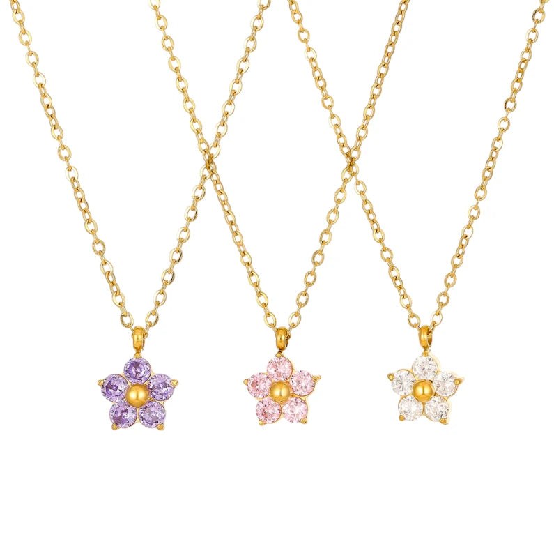 Flower necklace trio featuring purple, pink, and white cubic zirconia flower pendants on gold chains.