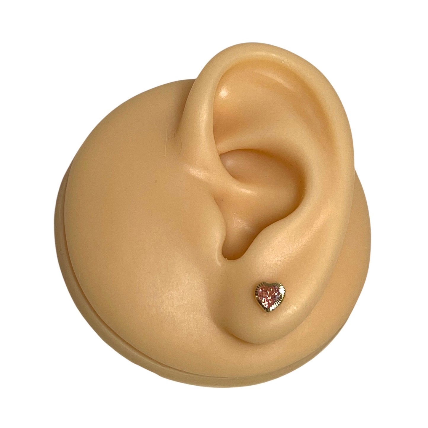 Heart earrings - 14k solid gold pink CZ heart stud showcased on a model ear.