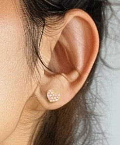 Heart Earrings in solid 14k yellow gold with AAA cubic zirconia, showcasing a charming design on a model's ear.
