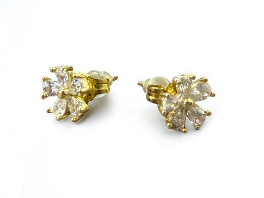 Gold flower-shaped earrings with clear gemstones on a white background