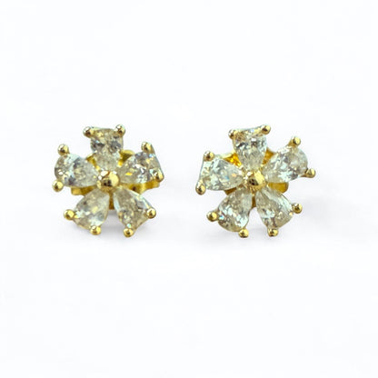 Pair of gold earrings with clear gemstones on a white background