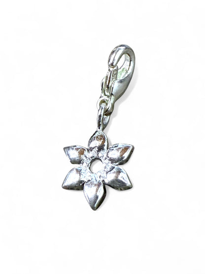 Silver flower-shaped charm on a white background