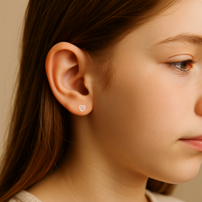 Close-up of a person wearing a heart-shaped earring with a neutral background