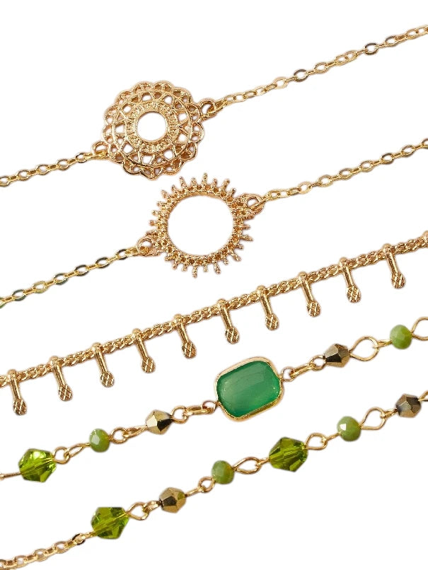 Layered bracelet set featuring green crystal accents and gold details, perfect for a trendy layered look.