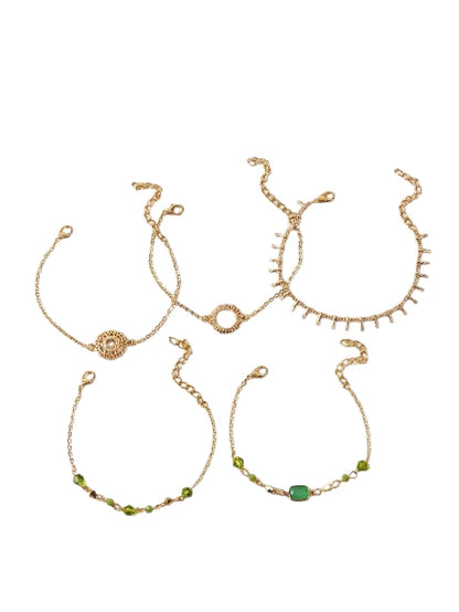 Layered bracelet set featuring gold chains and green accents for a trendy layered look.