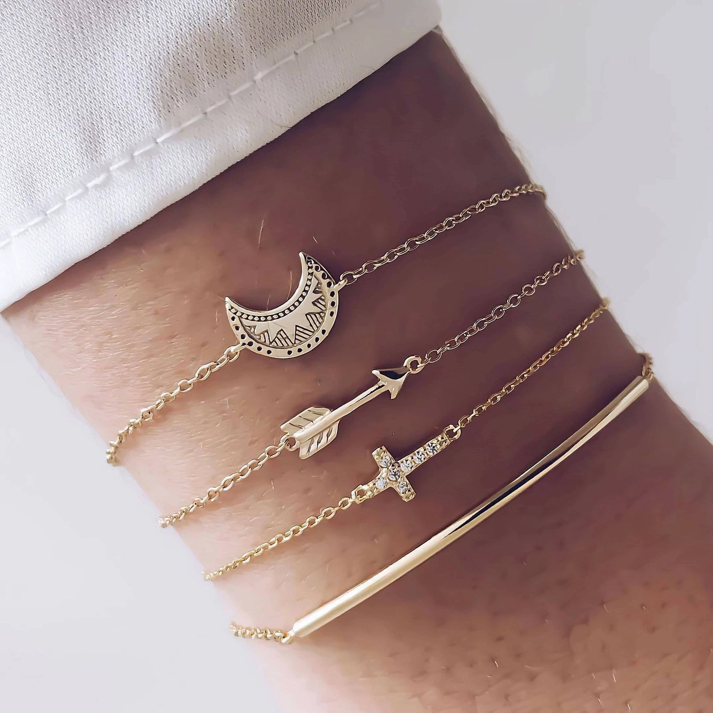 Layered bracelet set featuring three gold bracelets with lunar and arrow accents, perfect for stylish layering.