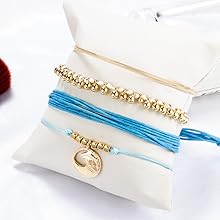 Layered bracelet set featuring three ocean-inspired bracelets on a white display cushion.